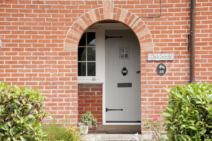 Front door with brick surround and composite door with black finishings.