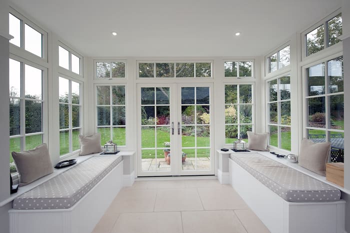Interior of an orangery extension with triple aspect and double doors to the patio.