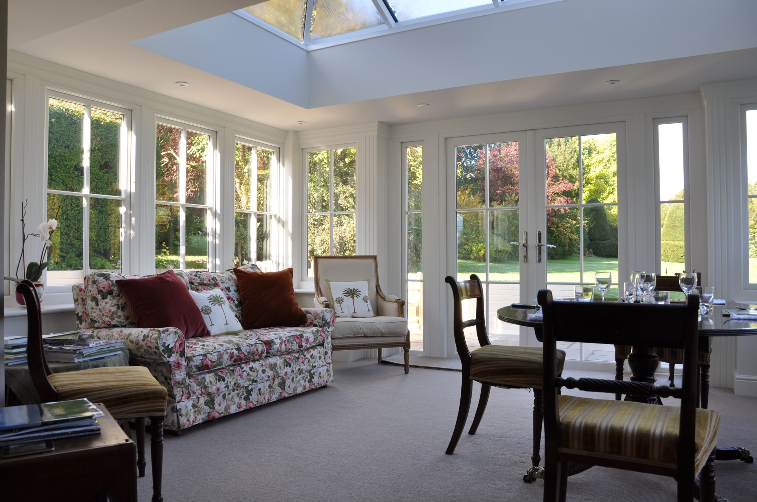 Interior of a living room diner with patio doors to garden and roof lantern.