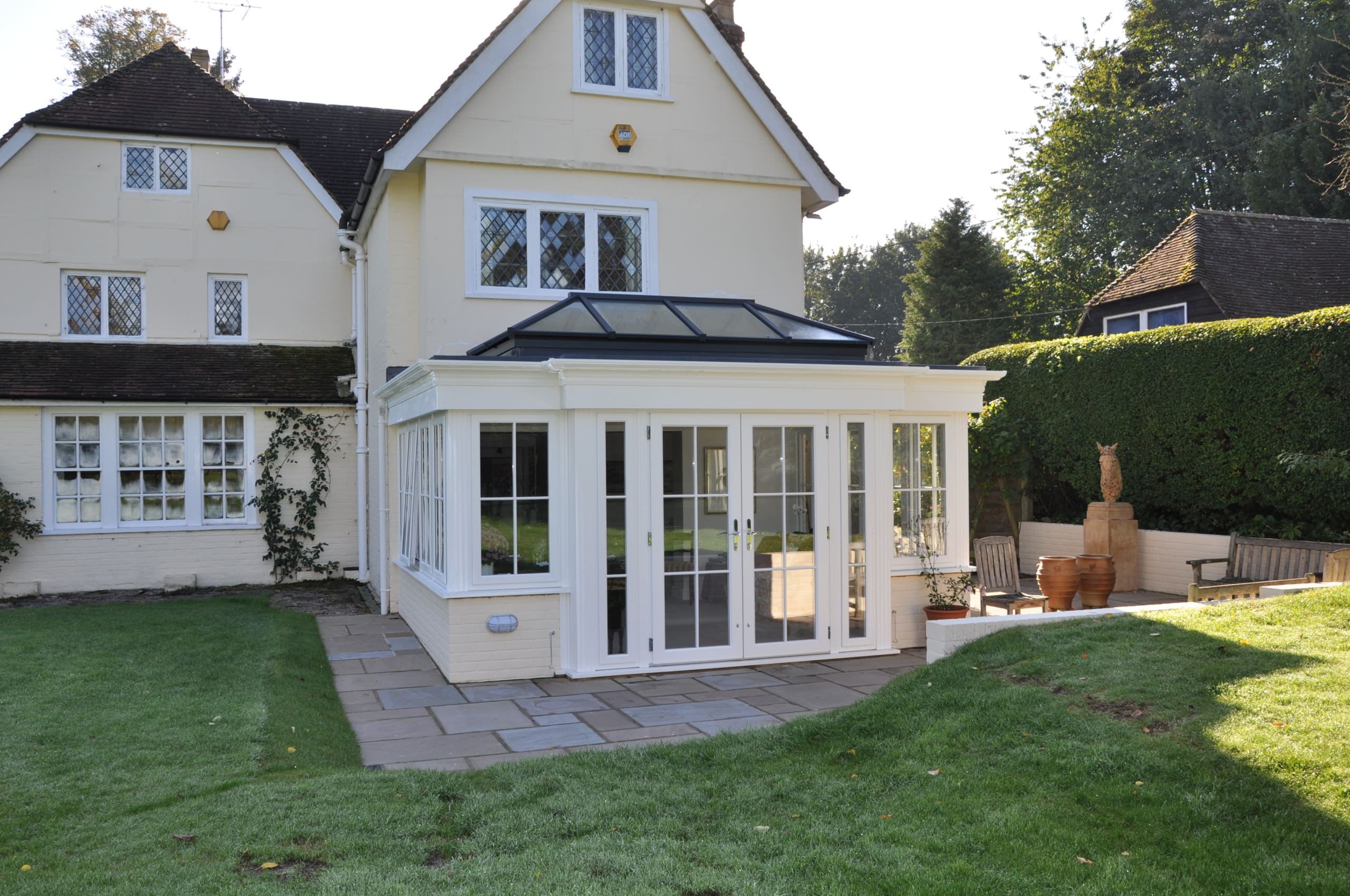 Substantial property on a warm autumnal morning with orangery and roof lantern.