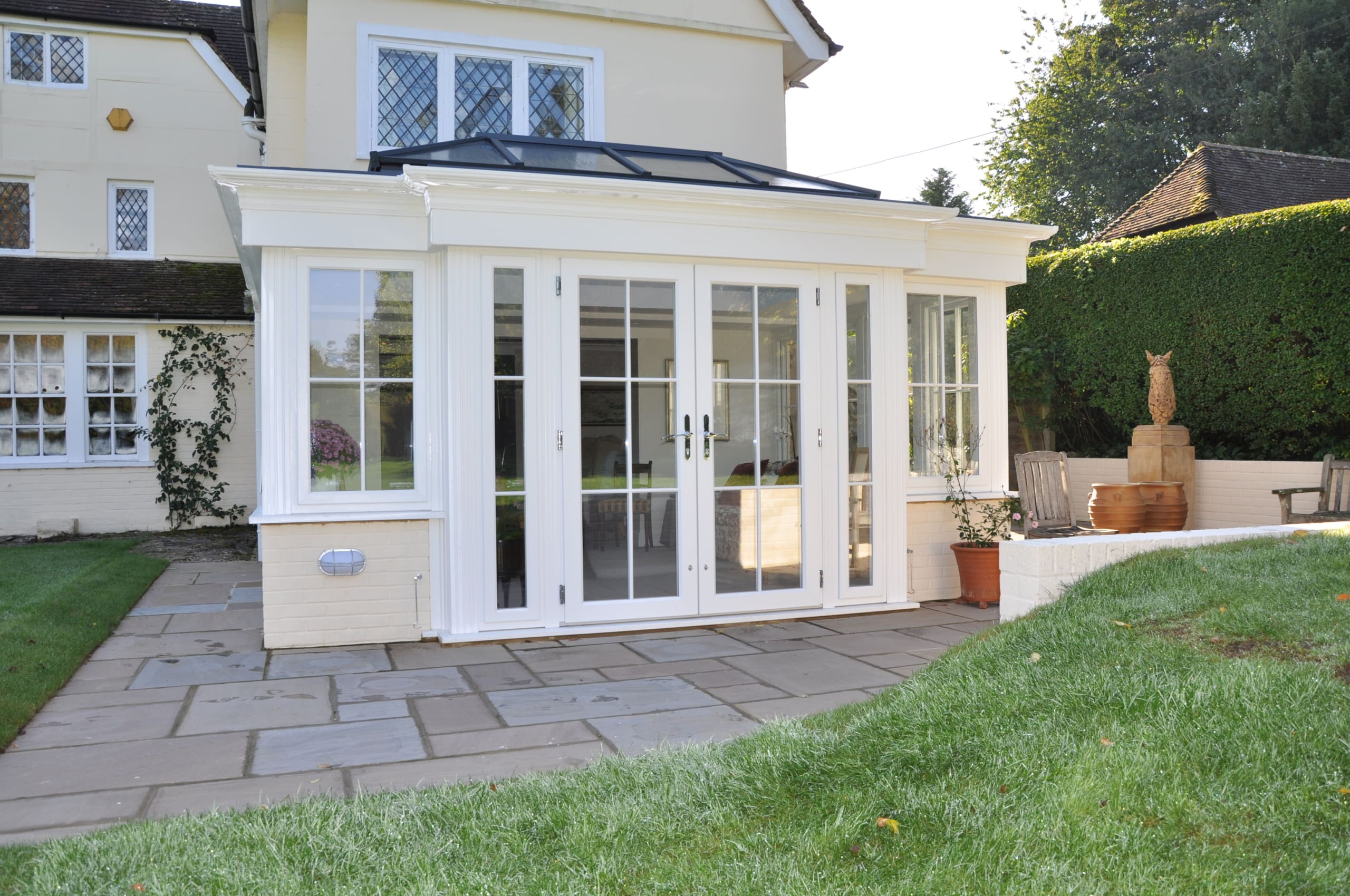 Orangery extension with roof lantern and white framework.