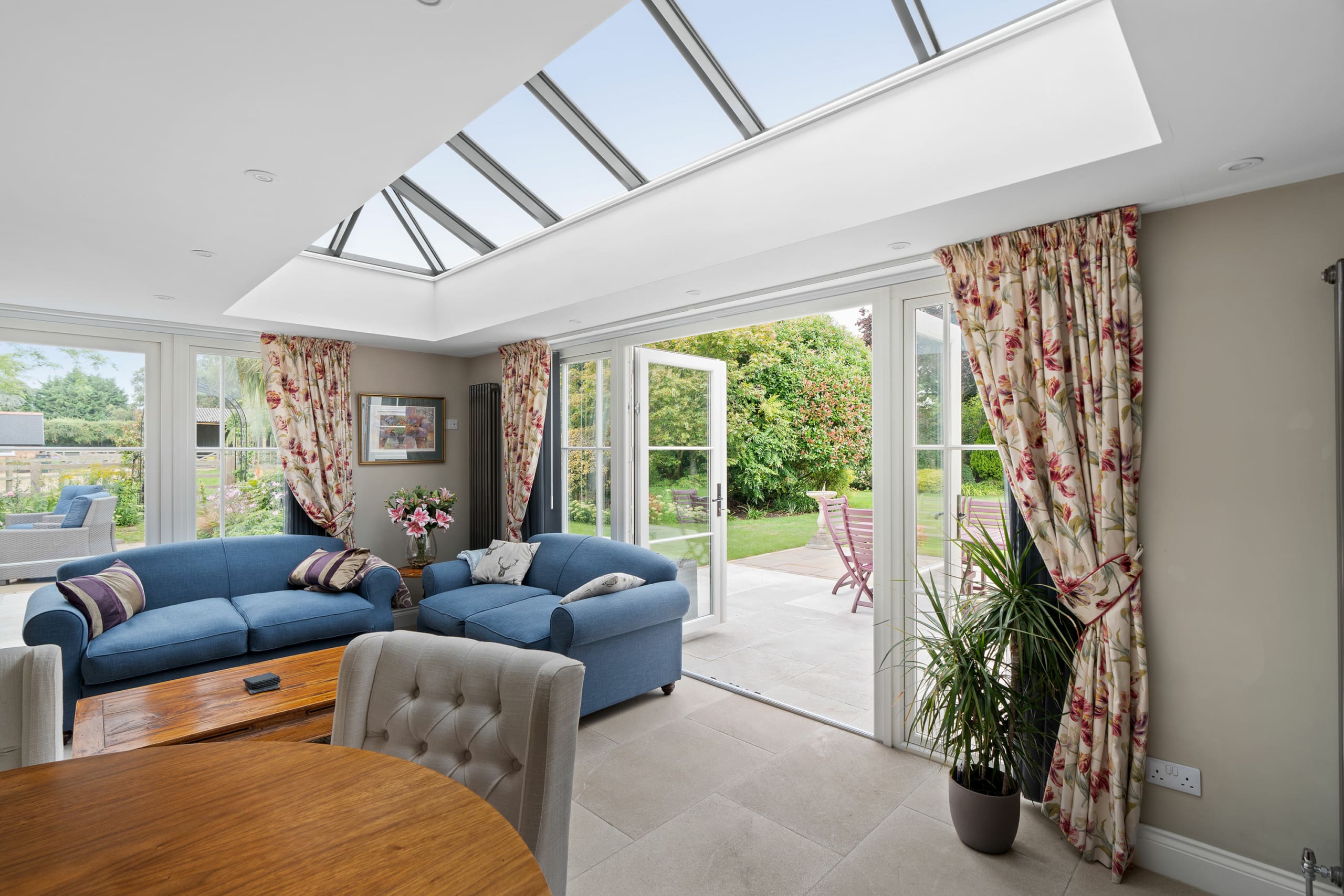 Traditional living room and dining area with a roof lantern and french doors leading to pation area.
