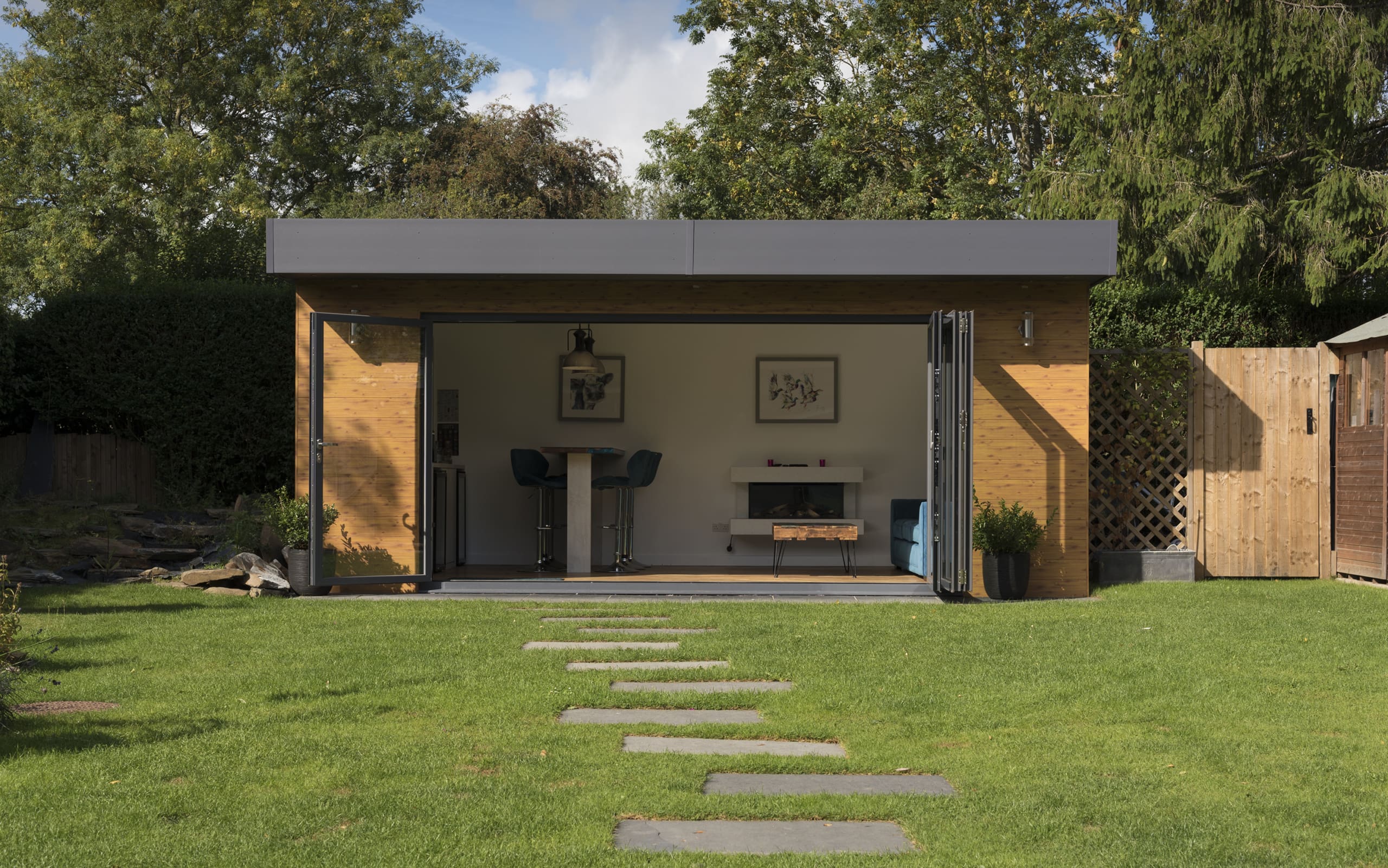 Garden house with modern furniture and bifolding doors.