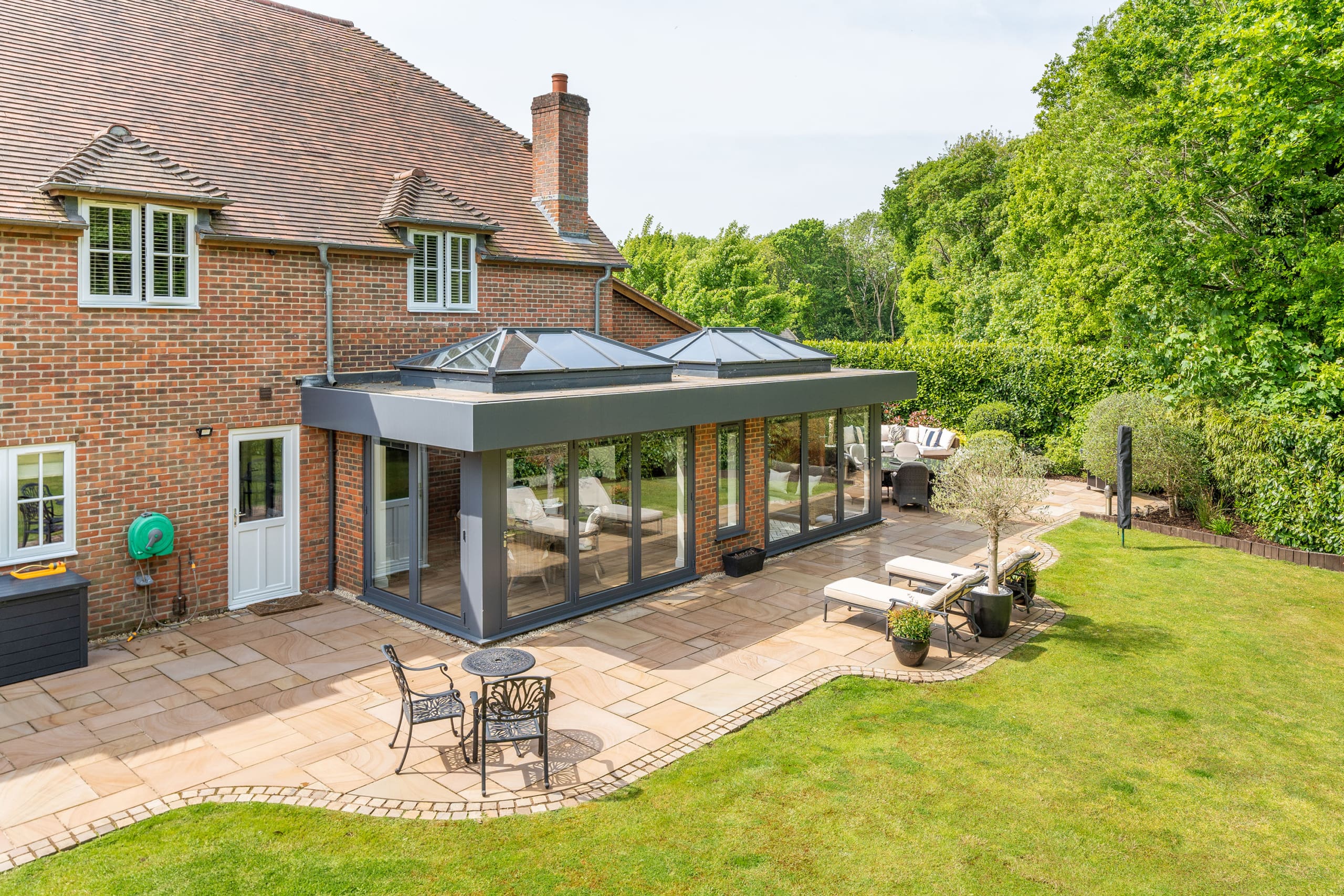 Exterior of an orangery extension with an elevated view of the landscaped garden.