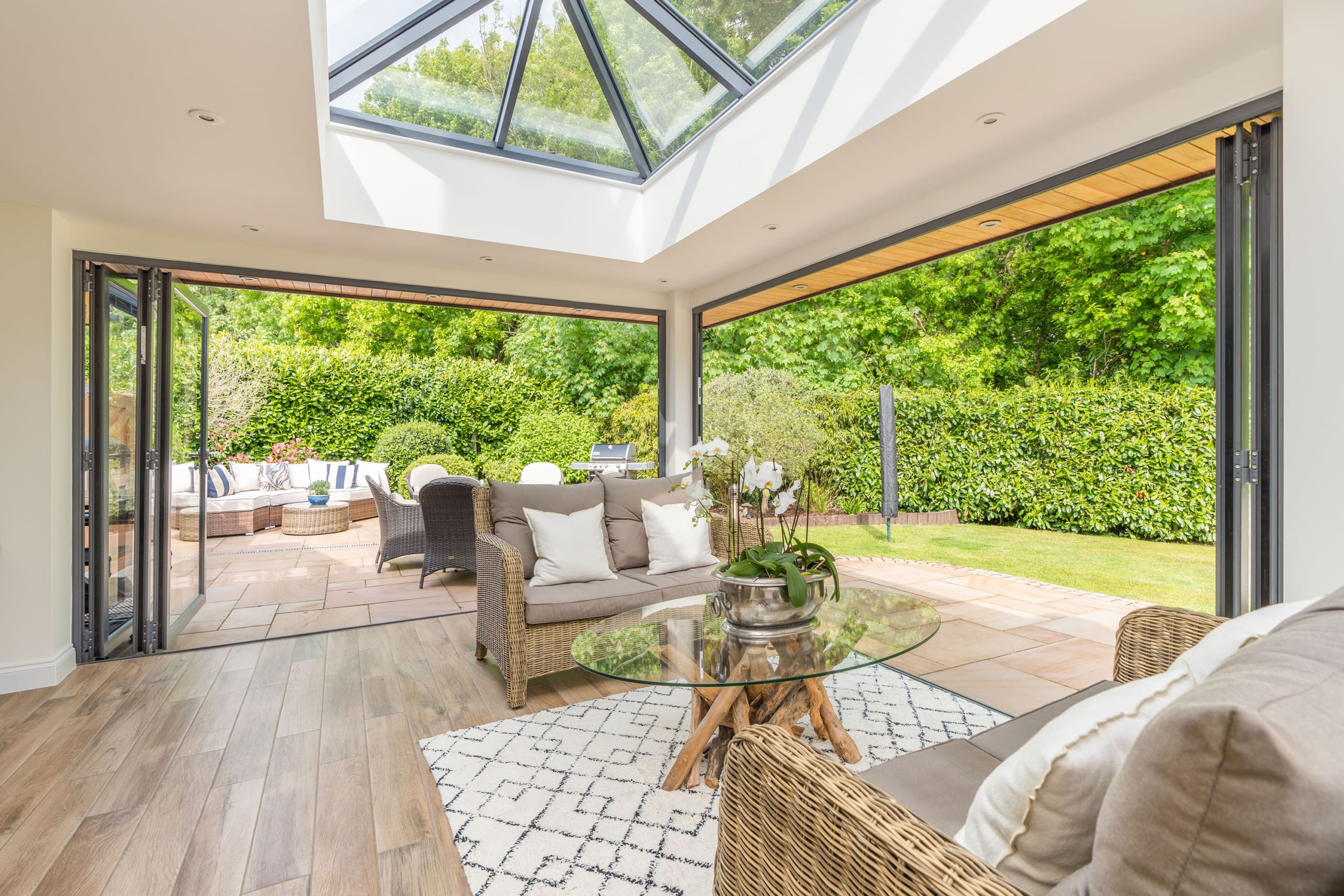 Interior of a orangery extension with bifolding doors and roof lantern.