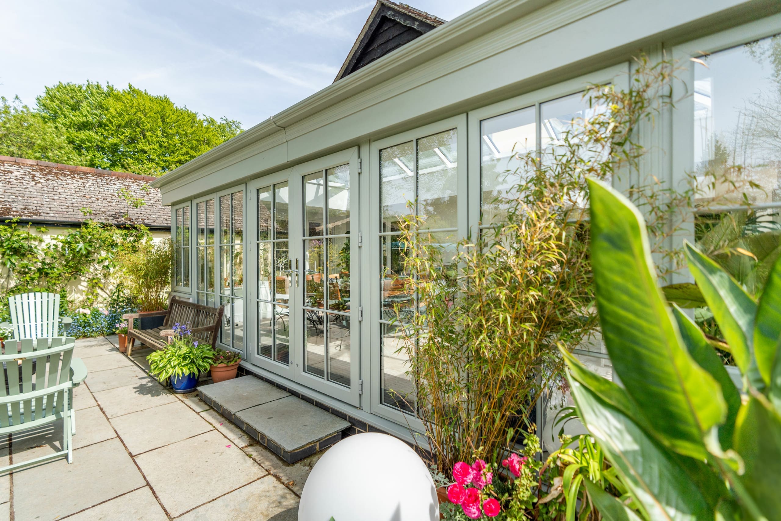 Exterior of a stunning orangery extension finished with green framework.