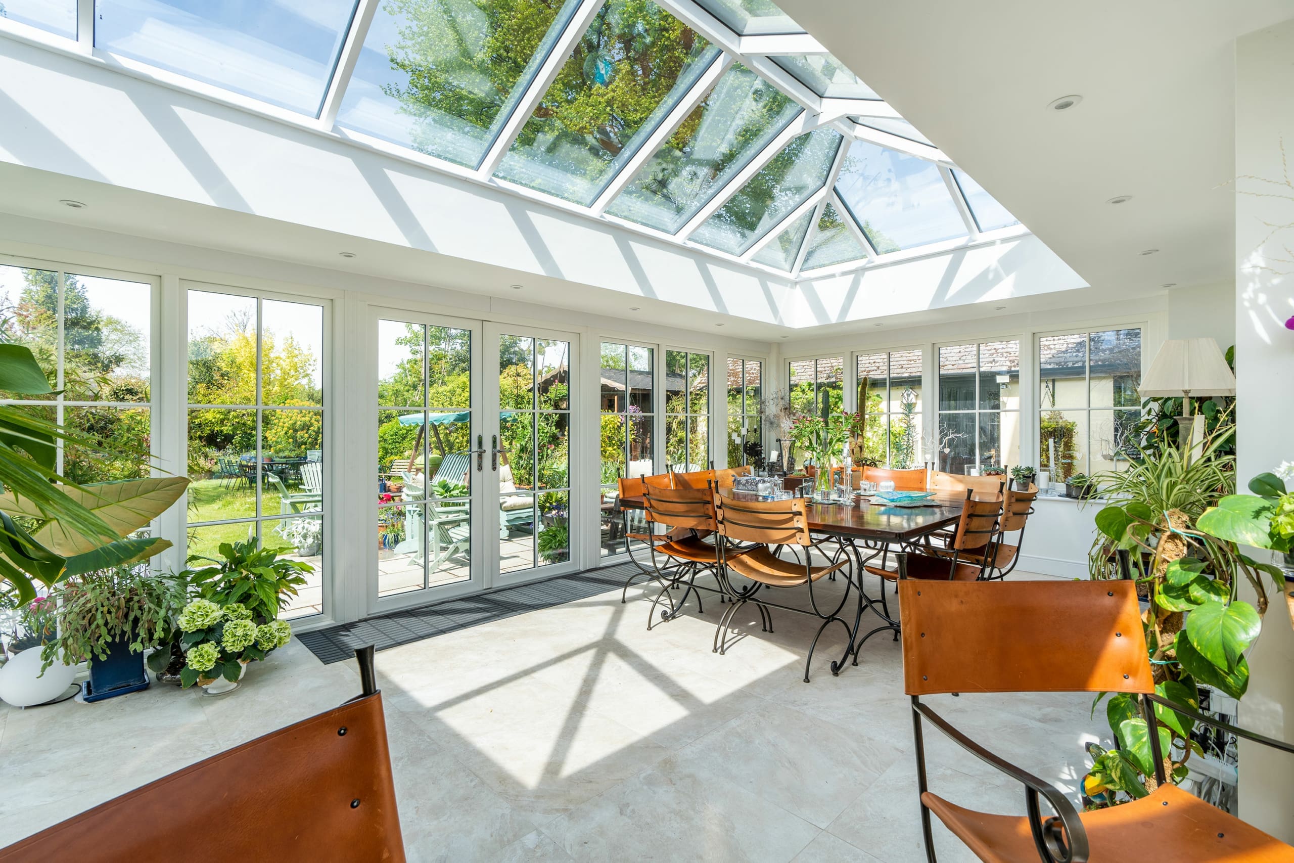 Interior of a stunning garden room with roof lantern and dining furniture.