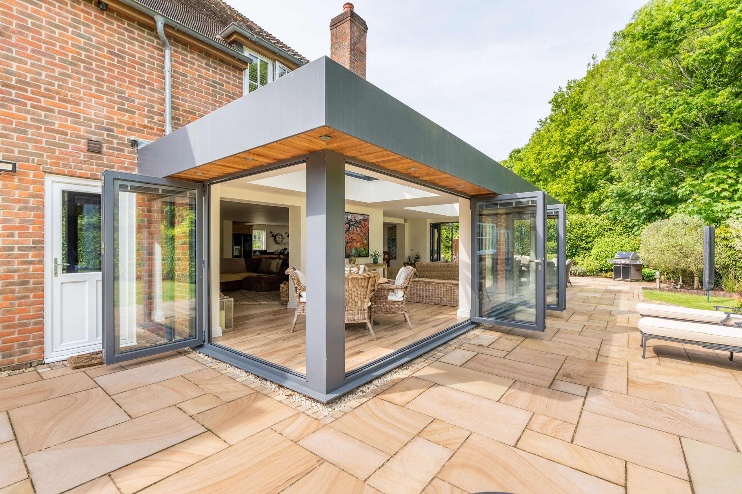 Exterior of an orangery with bifolding doors and roof lantern.