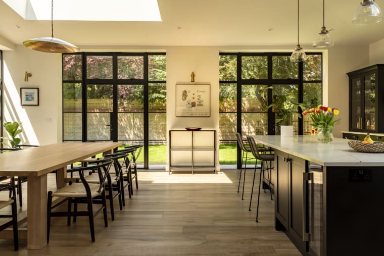 Beautiful kitchen diner with scandinavian dining table, kitchen island and aluminium windows.