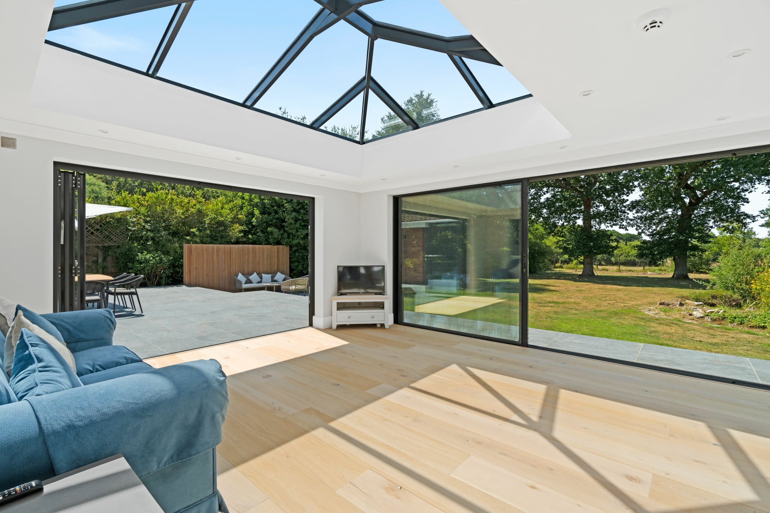 Beautiful modern extension with black aluminium glazing including sliding doors and roof lantern.
