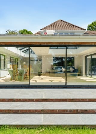 Orangery with glass doors connected to back of substantial property