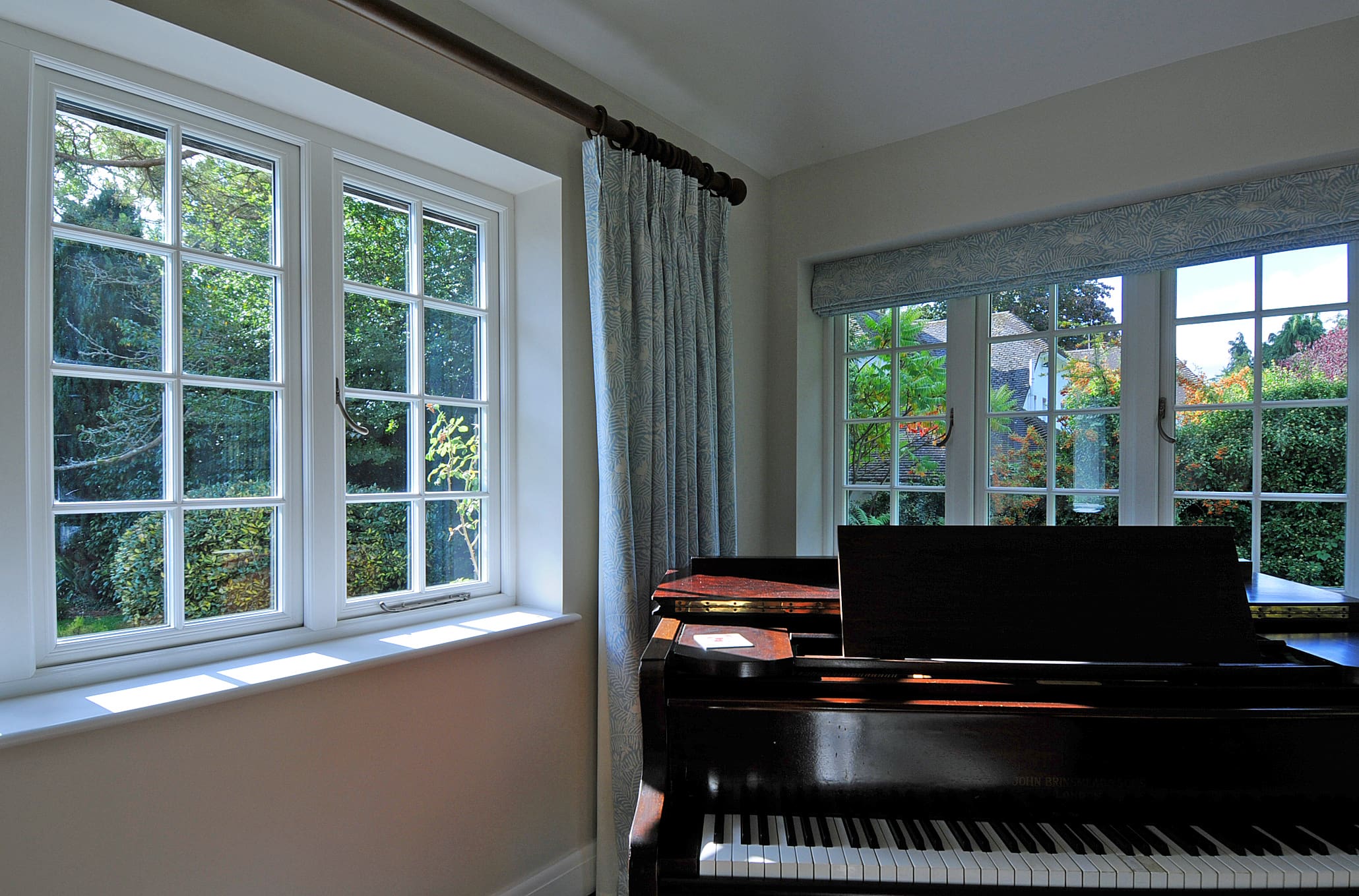 Traditional home with piano and windows.