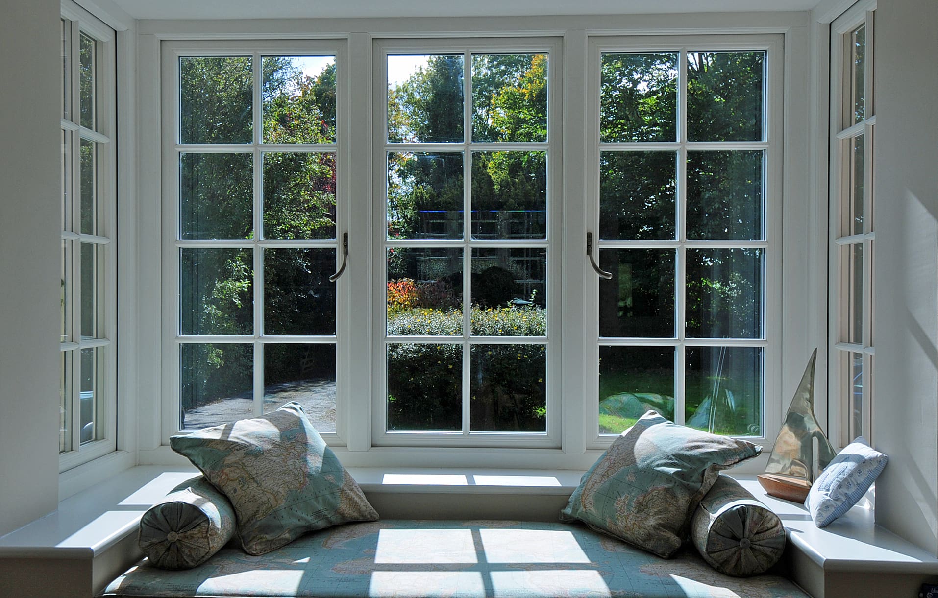Internal bay window in a traditional style with a window seat and round cushions.