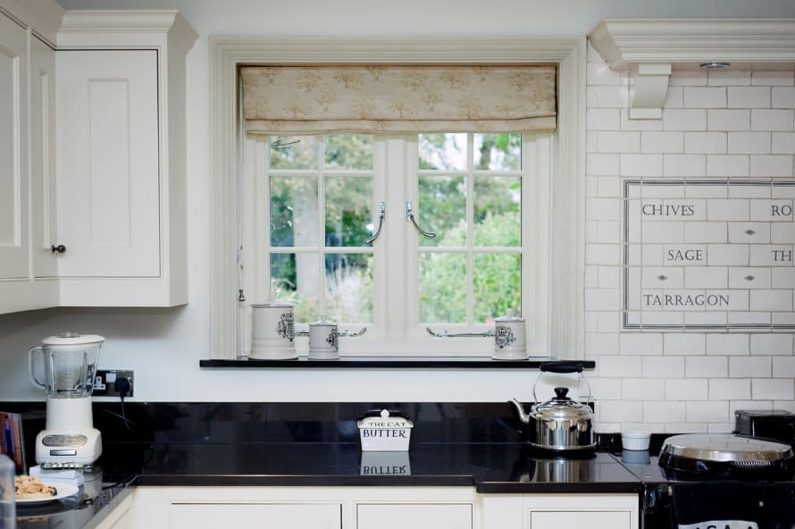 Traditional style kitchen with storm 2 windows and silver handles.