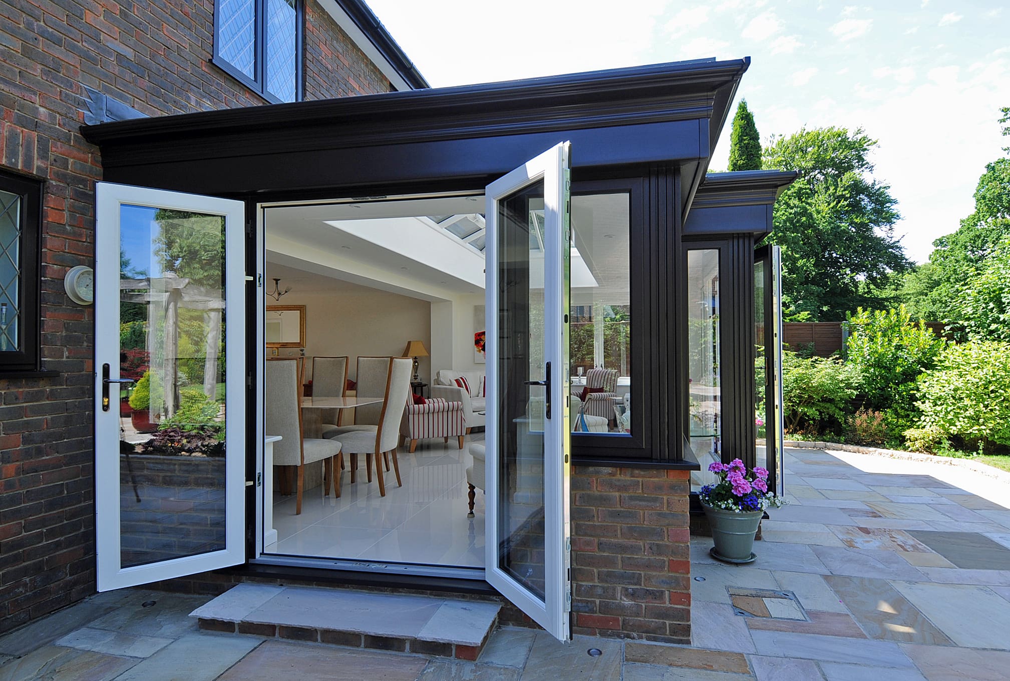 Side view of a kitchen extension with the french doors open and a view into the living area.