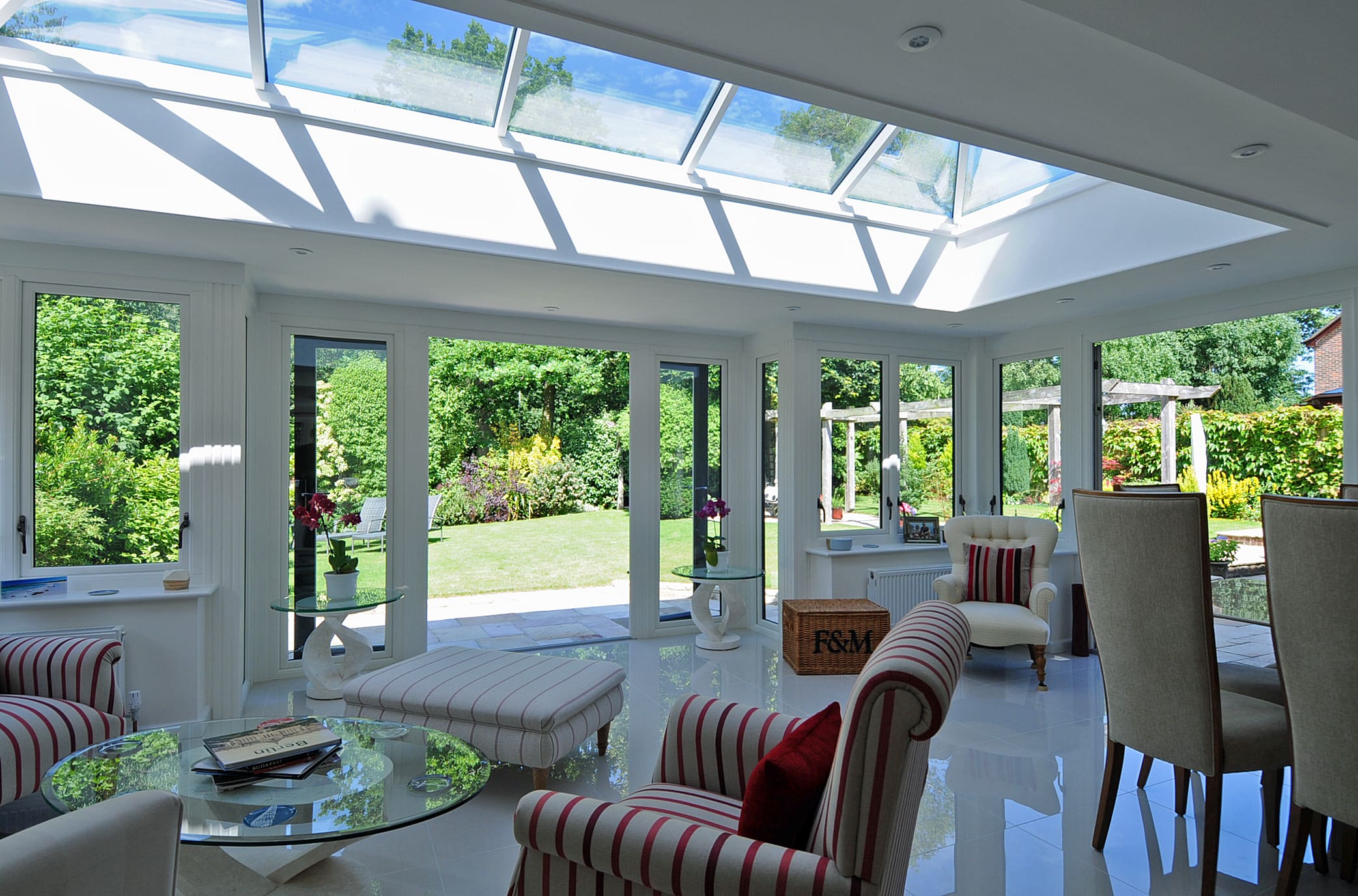 Beautiful sitting room with striped armchairs and double glazed french doors and a roof lantern.