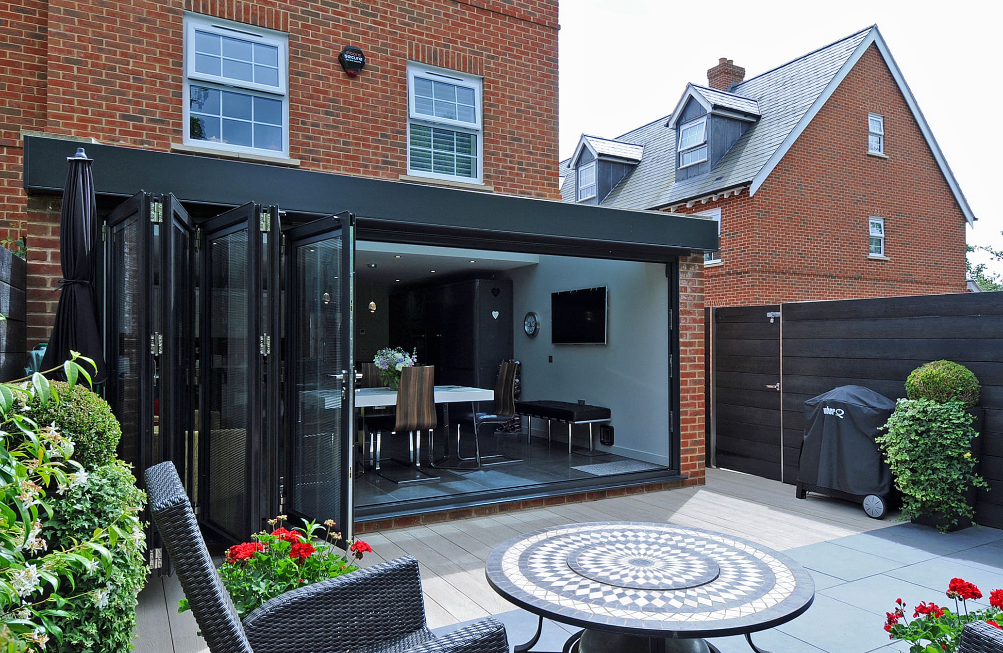Rear view of an extension with bi-folding doors with modern dining table.