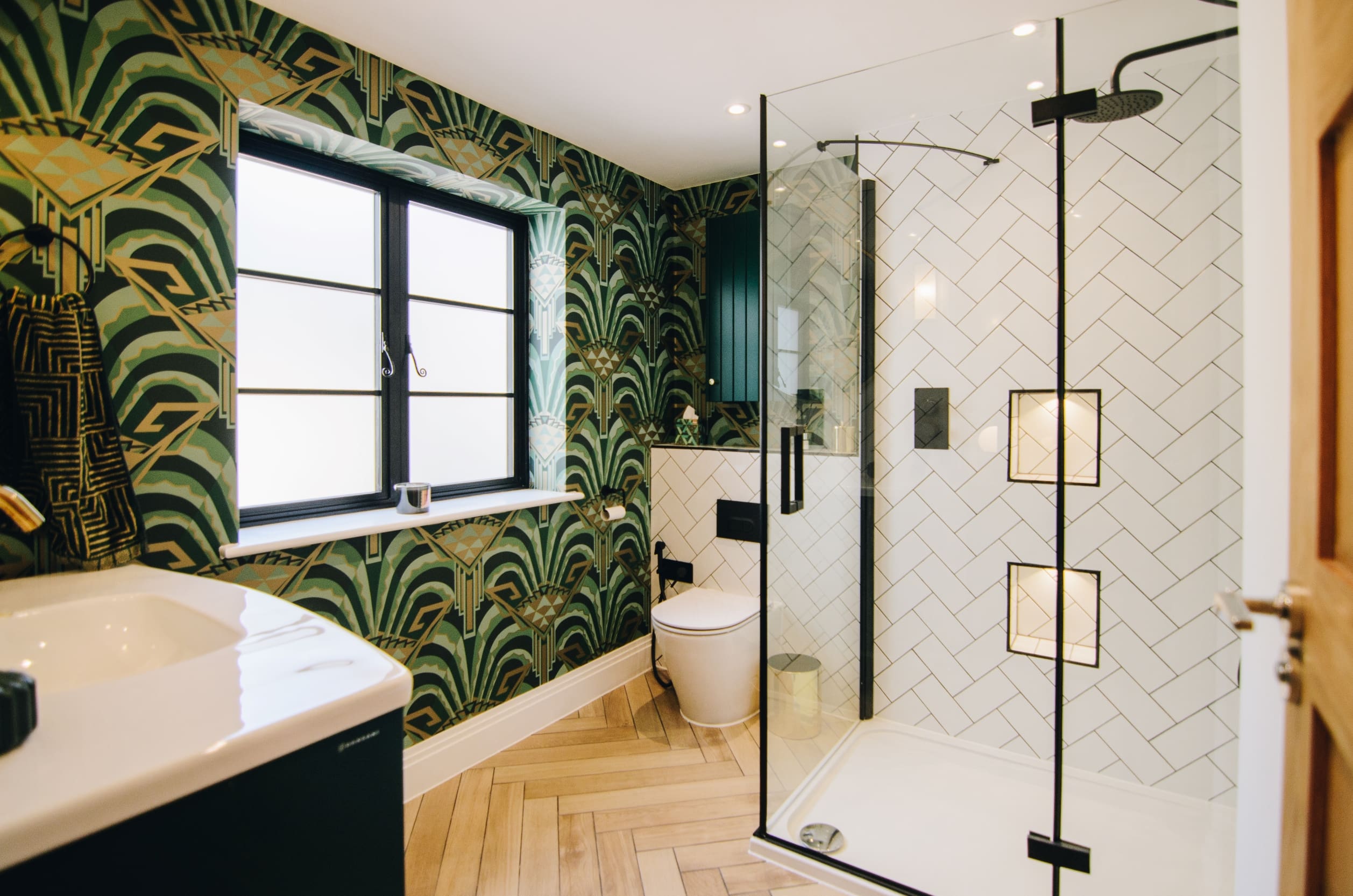 Art deco bathroom with herringbone wooden tiled floor and aluminium windows.