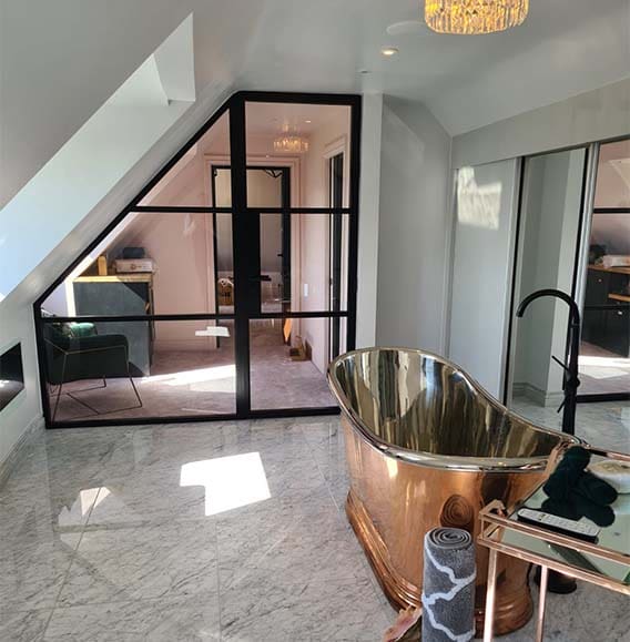 Beautiful modern bathroom with copper freestanding bathtub and aluminium internal Aluco doors.