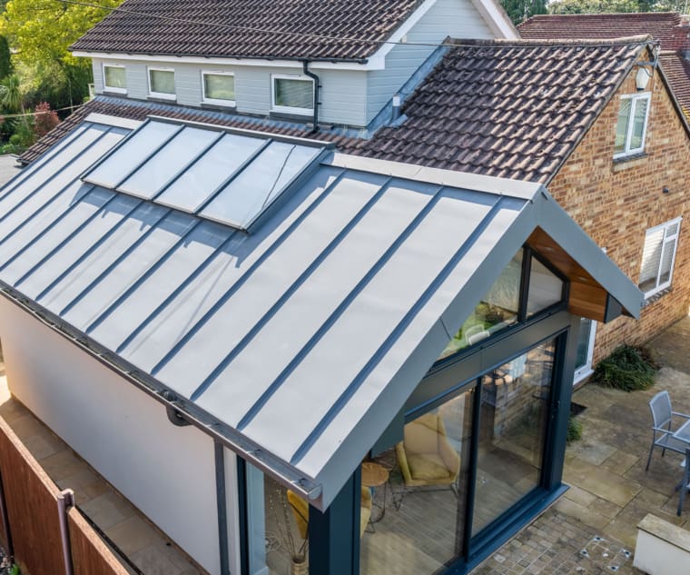 Zinc roof extension to a property with sliding aluminium doors.