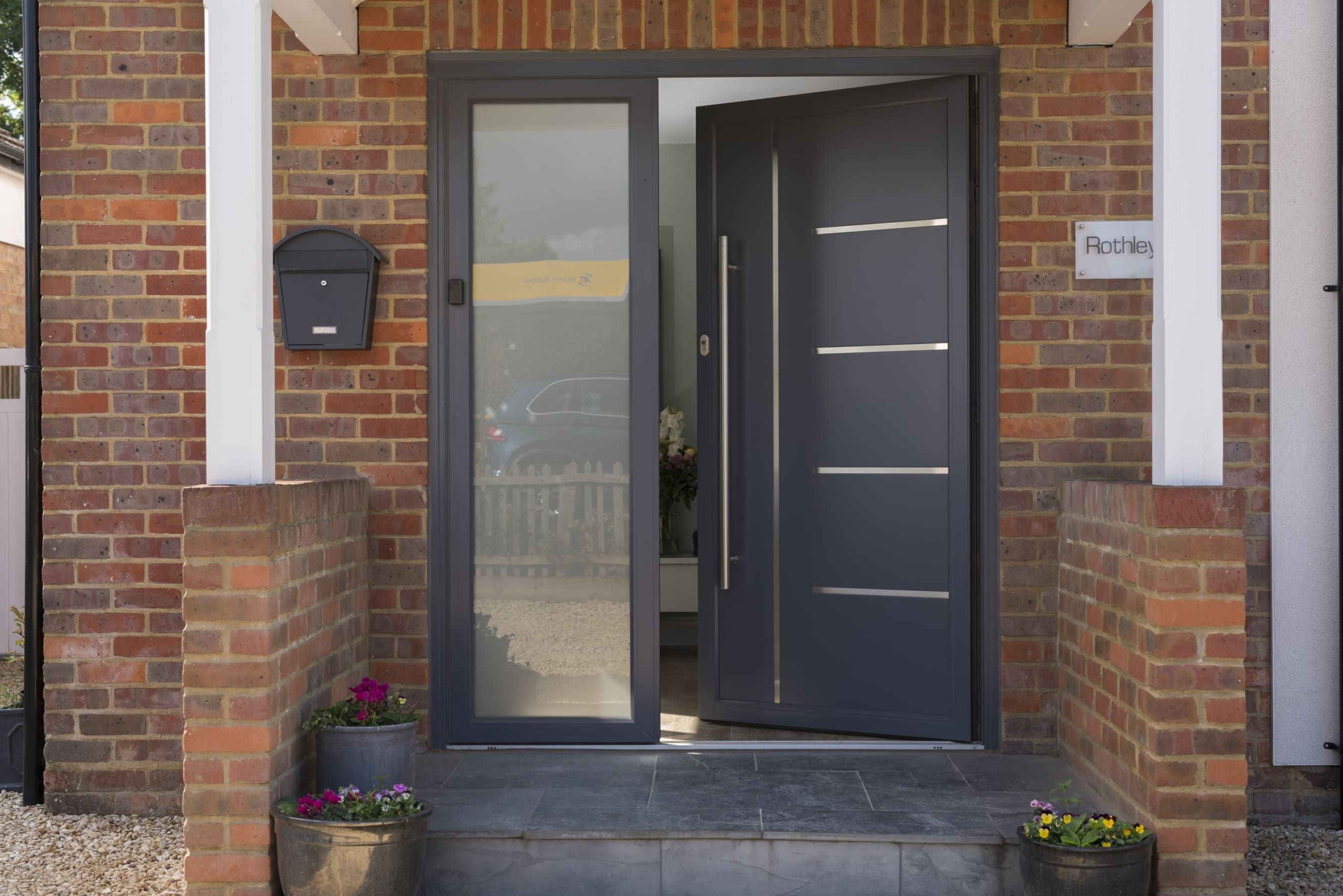 Contemporary composite door in grey with silver furnishings.