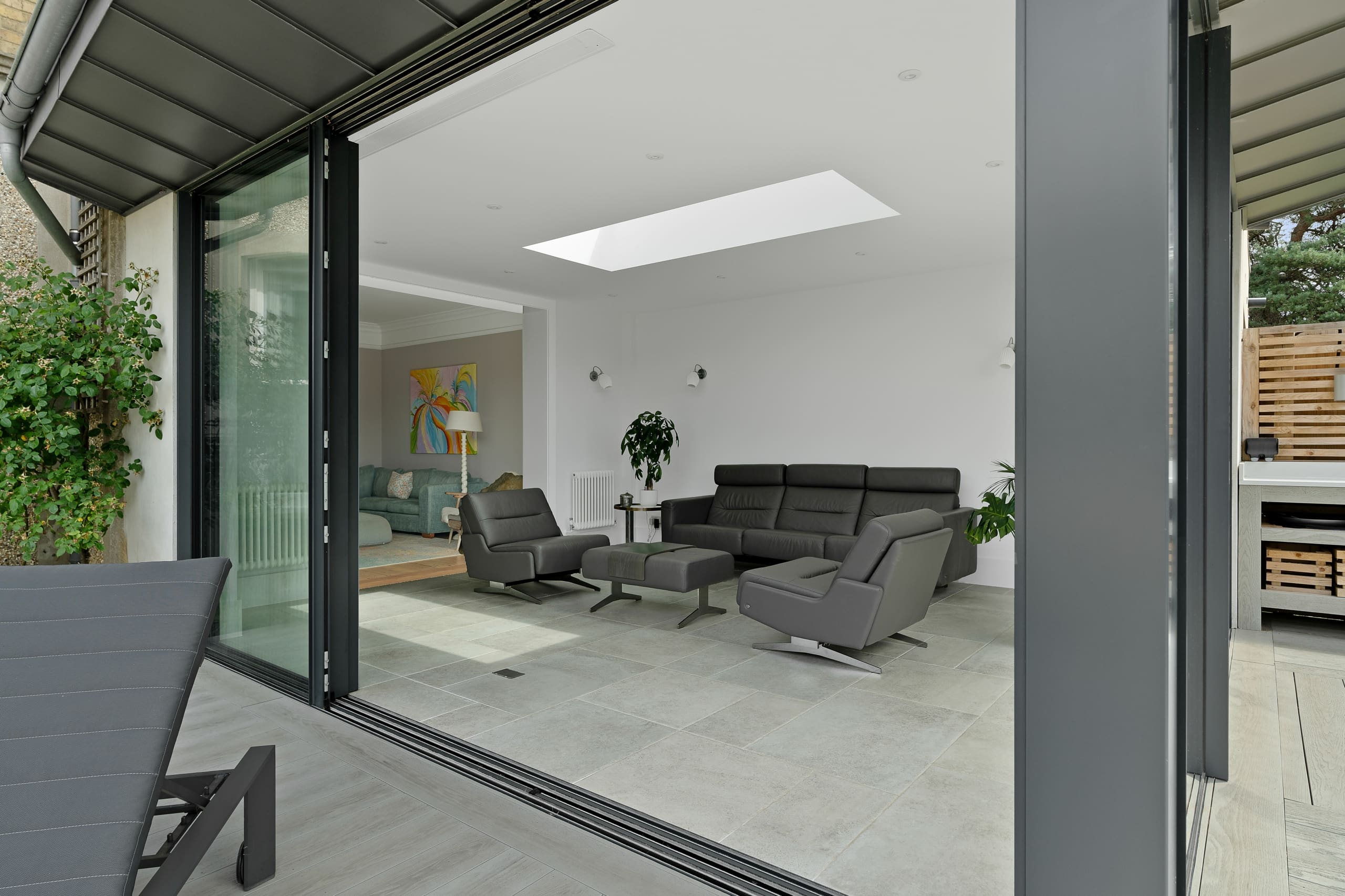Modern lounge with sliding external aluminium doors leading to a garden.