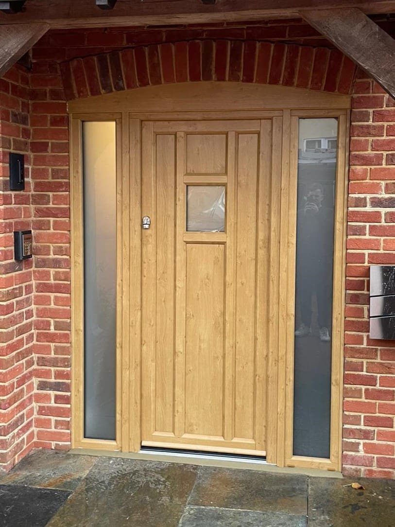 Traditional front door to property in wood effect with glazed panelling.