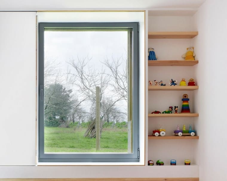 Glass within with grey framework and a set of shelves displaying childrens toys.